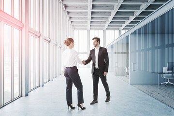 Businessmas makes deal with businesswoman inside office with pan
