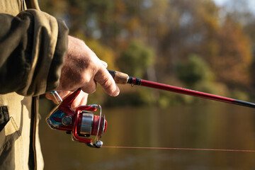 fisherman spins a reel on a spinning rod