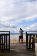 Ornithologist observing from a platform by seaside