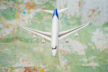 Fototapeta na wymiar Airplane travel concept. A toy plane flies over the geographic map of the world. 