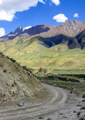 Sharp turn of the dirt road into a narrow mountain valley.