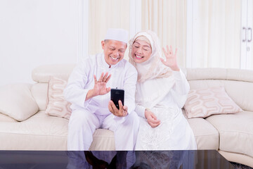 Muslim old couple waving hands front of cellphone