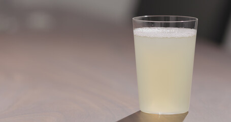 ginger beer into tumbler glass on walnut table