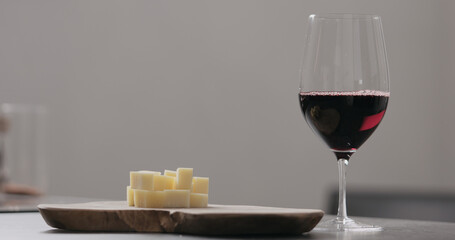 red wine in wineglass with vintage cheese on olive board
