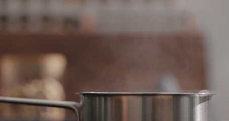 steam rising from saucepan with boiling water on kitchen closeup