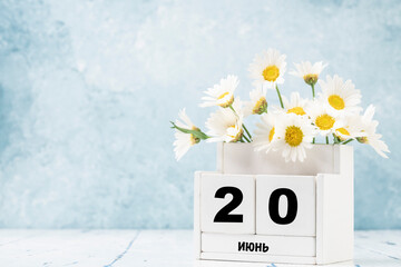 cube calendar for June in Russian with daisy flowers over blue