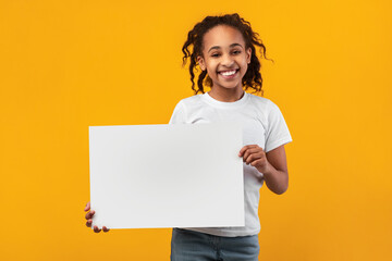 Black girl holding blank white advertising billboard at studio