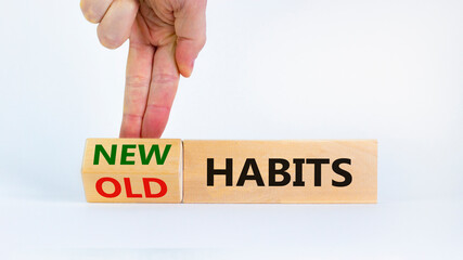 New habits symbol. Businessman turns a wooden block and changes words 'old habits' to 'new habits'. Beautiful white background. Business, psychological and new or old habits concept. Copy space.