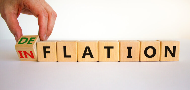 Inflation or deflation symbol. Businessman turns cubes and changes the word inflation to deflation. Beautiful white background, copy space. Business, inflation or deflation concept.