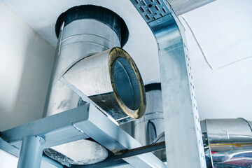 Fragment of a chimney. Stainless steel ventilation duct in an industrial boiler room. Installation...
