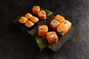 rolls and sushi on a black background. Horizontal