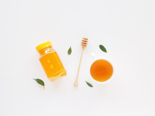 Top view healthy tea with honey set. Jar of honey with dipper and leaves