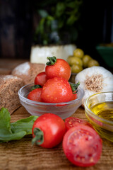 Basic ingredients of the Mediterranean diet: tomato, garlic, basil, whole wheat bread, cured cheese and extra virgin olive oil. Photo of Mediterranean cuisine ingredients