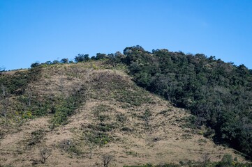 A big mountain covered with fresh green vegetation saw from the hiking trail that leads to Pedra da Macela viewing spots, in Serra da Bocaina national park in Paraty, Rio de Janeiro - Brazil.