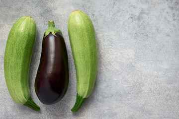 Raw zucchini and purple eggplant. Gray background with copy space, organic vegetables. Top view