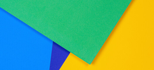 Creative abstract blue, green and yellow color geometric paper compositon background, top view