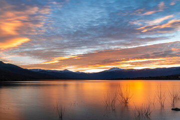 Atardecer en el lago con las montañas nevadas al fondo