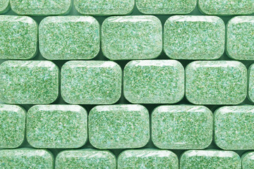 Green dishwasher detergent tabs background or texture.