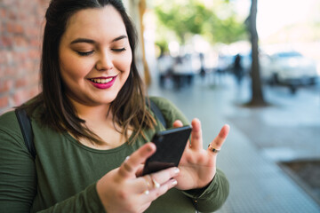 Young plus size woman using her mobile phone.