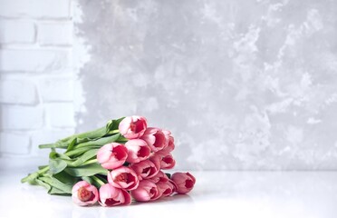 Bouquet of fresh pink tulips on white table. Copy space for text.
