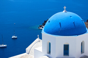 Oia town in Santorini, Greece.  Blue domed churches Agios Spyridonas and Anastaseos.