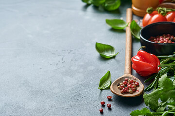 Food cooking background. Fresh rosemary, cilantro, basil, cherry tomatoes, peppers and olive oil, spices herbs and vegetables at black slate table. Food ingredients top view.