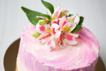 Fototapeta na wymiar Cake with pink decor and flowers