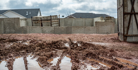 residential house construction under rain delay with mud and tracks