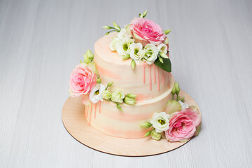 Fototapeta na wymiar Tiered cake with fresh flowers and macaroons