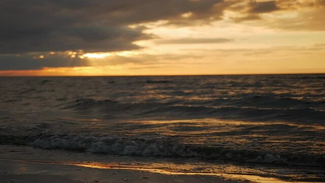 Sunset over a calmly rippling sea. Slow motion shot.