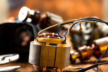 Power tool repair. Details of electrical appliance and repair tools on a wooden table in a repair...