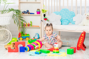 the baby is playing at home in the nursery. Toys for small children. A child with educational toys. Early development