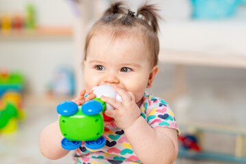 happy baby with a toy at home or in kindergarten. Toys for small children. early development