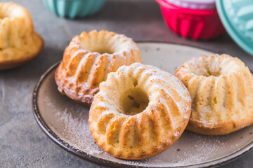 Homemade mini bundt cakes with powdered sugar on gray background