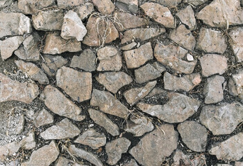 Texture, background of old, stone, cobblestone on an abandoned earth surface.