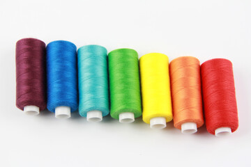 Colored, rainbow threads for sewing with a needle. Handmade concept, clothing repair. Top view. Flatley. Copyspace.