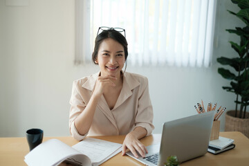 Portrait of happy woman sitting at her office. Attractive young confident business woman or accountant smiling and have idea for her big project.