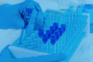 Close-up of a female researcher using a micropipette filling test tubes. A laboratory assistant in...