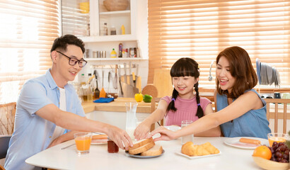 Obraz na płótnie Canvas Asian family enjoy eating breakfast together in kitchen room at home.