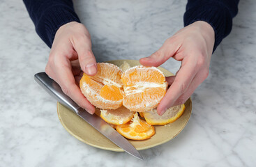 Man's hands peeling an orange. Healthy food concept