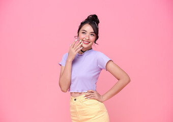 Happy young Asian teenage girl on pink background.