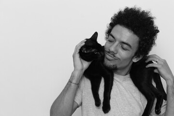 man on white background with black cat around his neck with black and white effect
