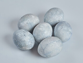 Painted eggs in blue and white lie on a white background.