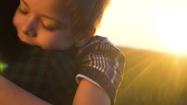 son hugs mom. concept happy family teamwork. boy kid hugs beloved mother sunlight at sunset. Womens day concept. girl parent have a tender relationship are in lifestyle love