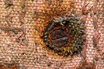 Extreme close up shot of rusty nail in old weathered fabric