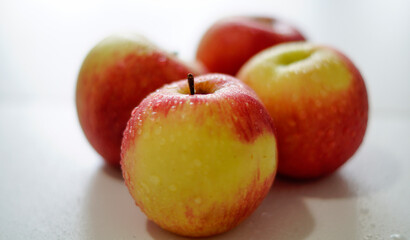 Four fresh organic apples on a white background.     