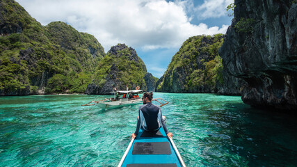 El Nido, Palawan Island, Philippines, traveler sitting on boat deck exploring the natural sights...