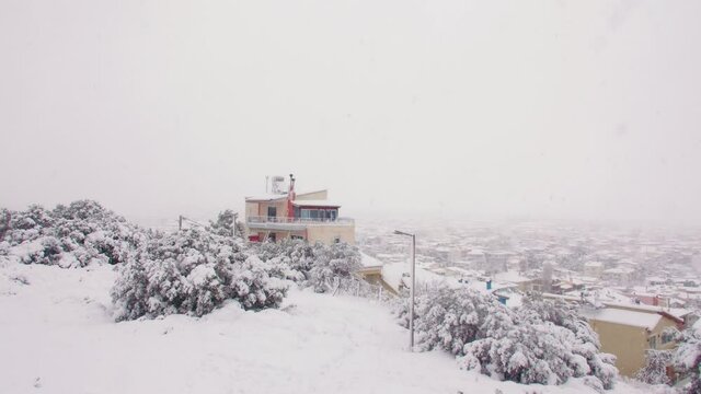 Rare abnormal Medea blanket snow storm across domestic Greek neighbourhood city landscape slow right panning