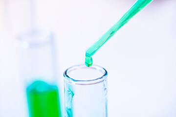 Chemical test tubes and pipette with green liquid close up in a chemical laboratory