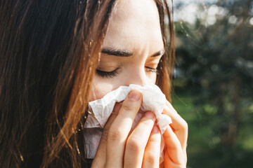 The woman blows her nose